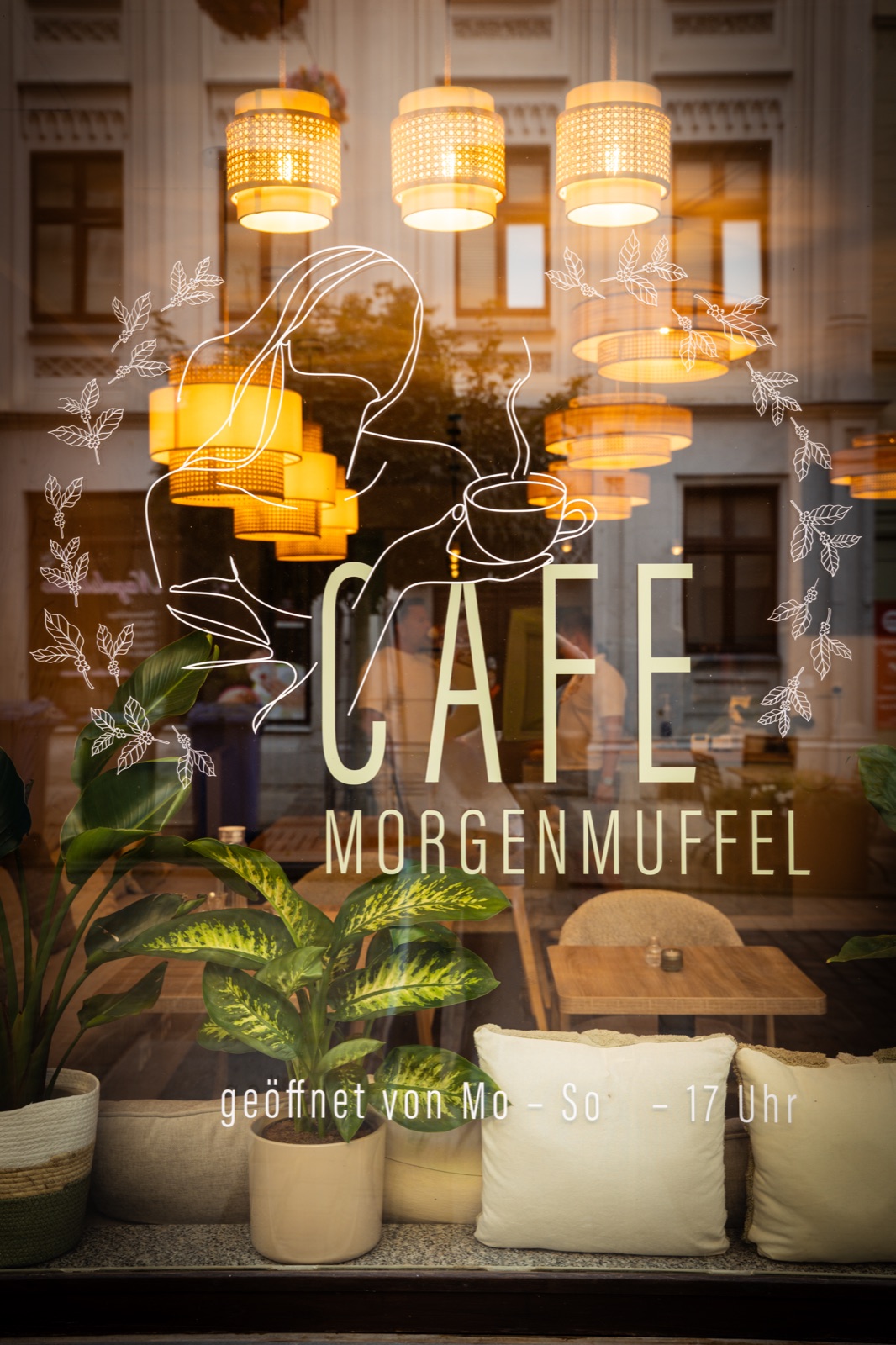 Gemütlicher Fensterplatz mit Kissen und Logo im Café Morgenmuffel Torgau